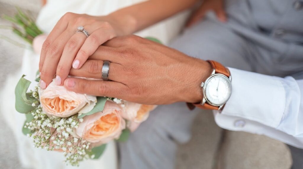 Bride and Groom holding hands on the bouquet