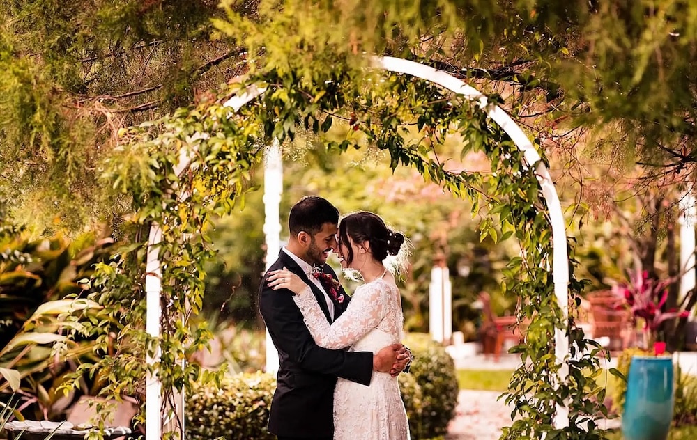 Couple getting married under the arbor at one of the most romantic Durham wedding venues